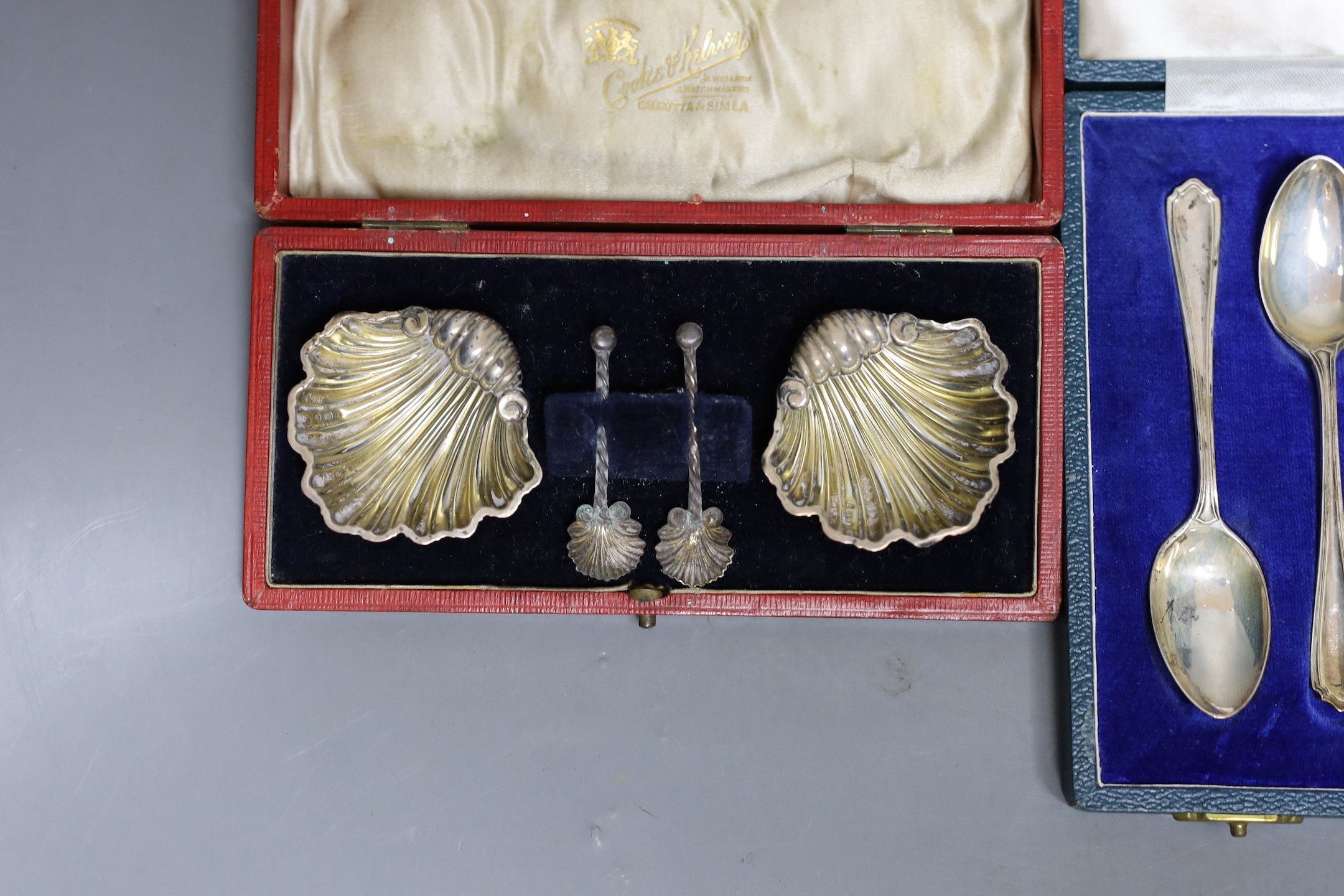 A cased pair of Edwardian silver shell salts and matching spoons, Birmingham, 1903, 51mm and a cased set of six modern silver teaspoons.